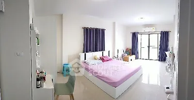 Spacious bedroom with modern decor and natural light, featuring a large bed and stylish furnishings.