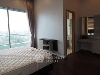 Spacious bedroom with city view and attached bathroom in modern apartment.