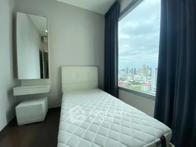 Modern bedroom with city view, featuring a single bed and sleek decor.