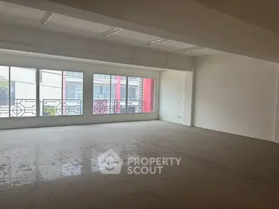 Spacious unfurnished room with large windows and natural light, ideal for customization.