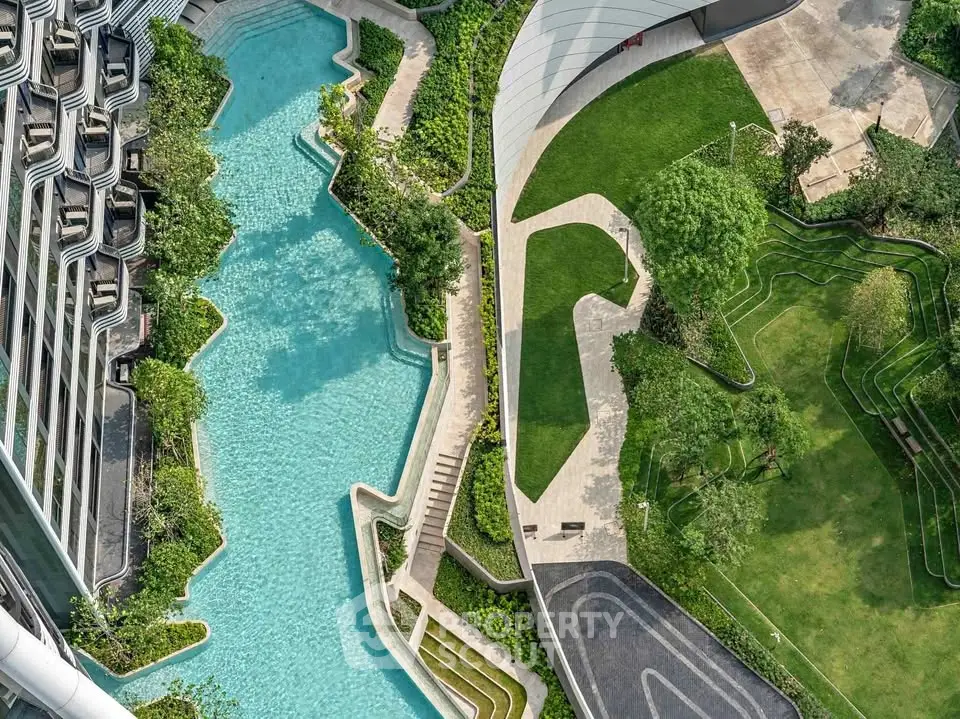 Stunning aerial view of modern building with luxurious pool and landscaped gardens, perfect for urban living.