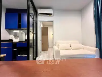 Modern living room with blue kitchen cabinets and cozy white sofa