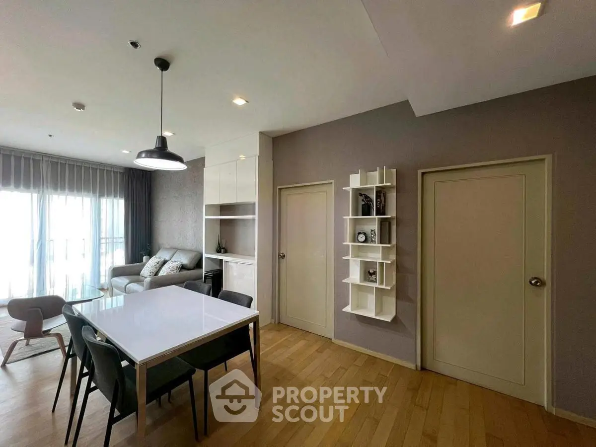 Modern living room with dining area, stylish decor, and natural light.