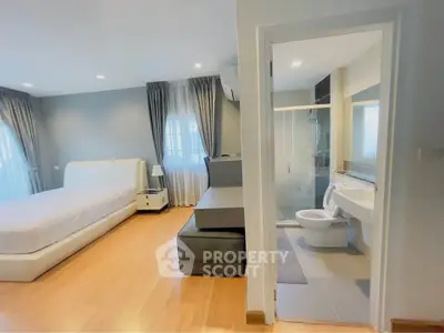 Spacious bedroom with ensuite bathroom in modern apartment