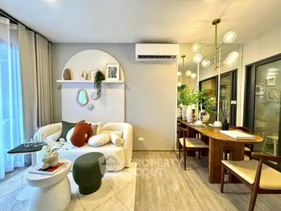 Stylish living room with modern decor and dining area, featuring elegant lighting and cozy seating.