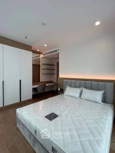 Modern bedroom with sleek design, featuring a large bed, built-in wardrobe, and stylish lighting.