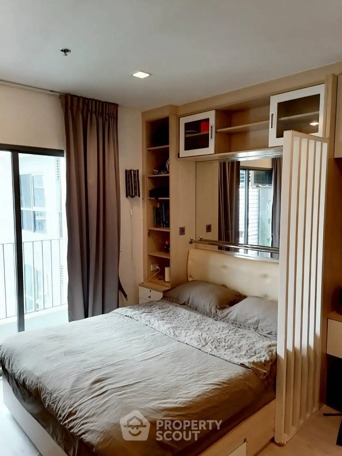 Cozy bedroom with modern furnishings and balcony view in urban apartment