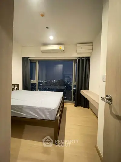 Modern bedroom with city view and air conditioning in high-rise apartment