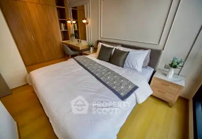Elegant bedroom with cozy bed, stylish decor, and ample storage in modern apartment.