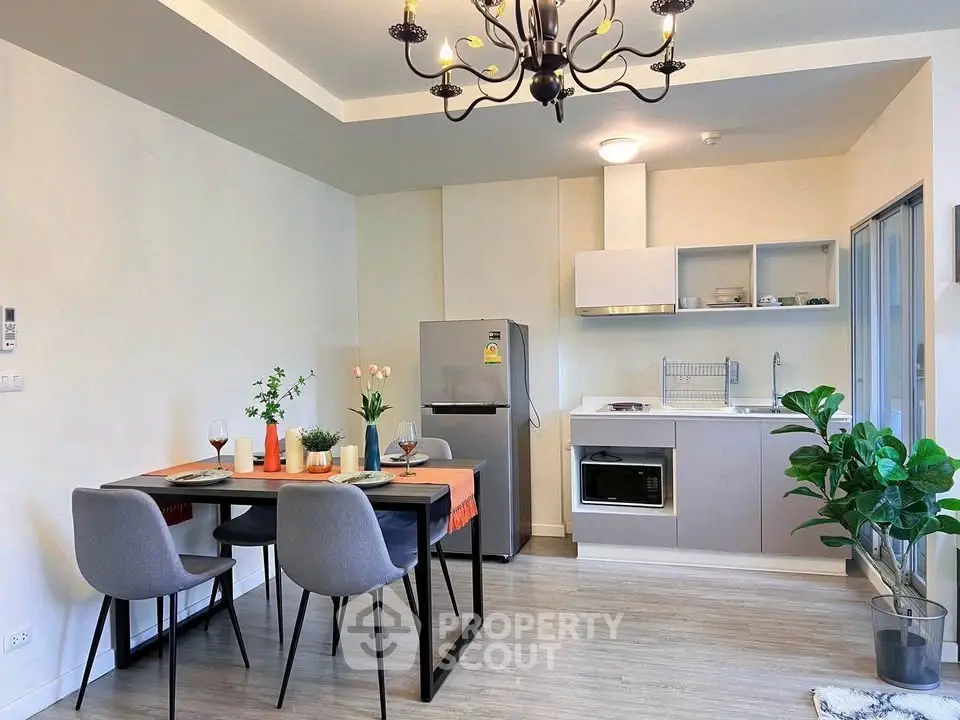 Modern kitchen with dining area, sleek appliances, and elegant lighting