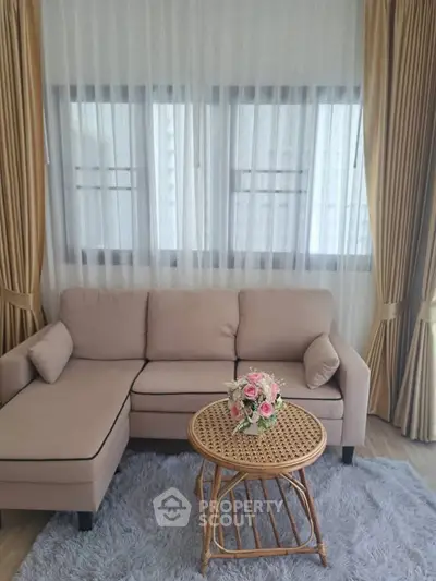 Elegant living room with cozy beige sofa, chic rattan table, and luxurious curtains for a stylish ambiance.