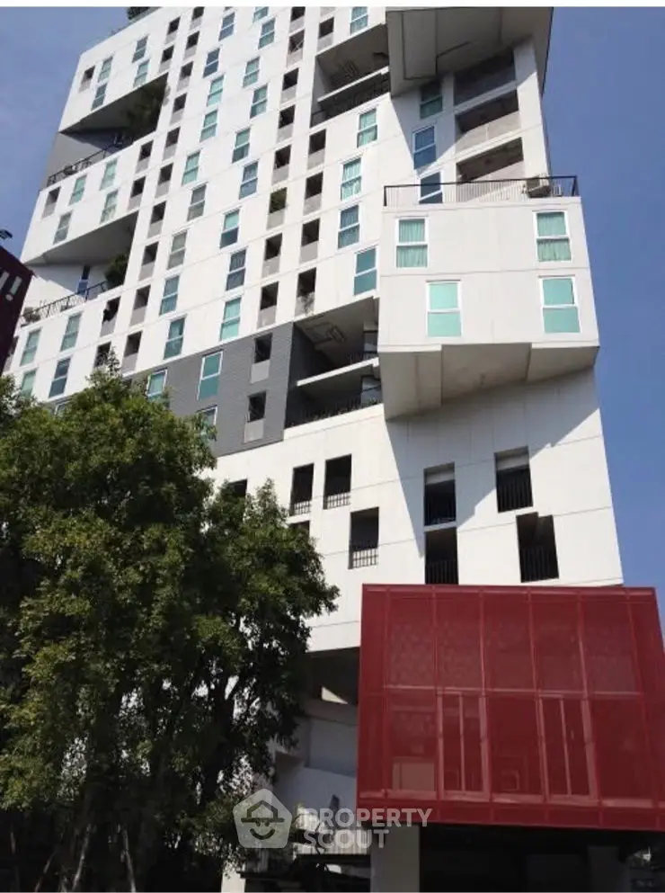 Modern architectural building with unique design and large windows in urban setting.