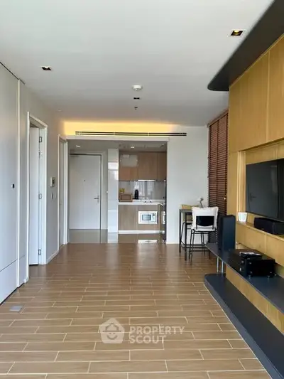 Modern open-plan living room with sleek kitchen and stylish wooden flooring.