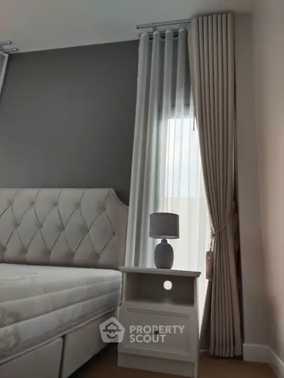 Elegant bedroom with plush headboard and stylish curtains