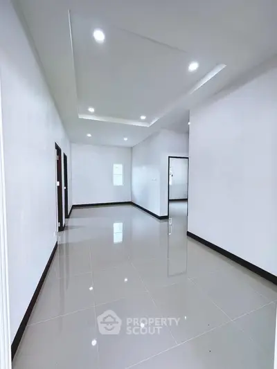 Spacious modern interior with glossy tiled floors and recessed lighting.