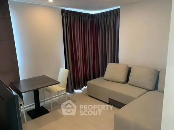 Cozy living room with modern sofa and dining table, perfect for relaxation.