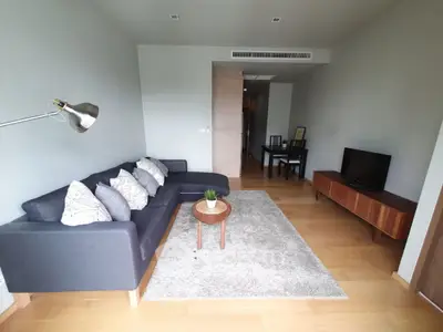 Modern living room with stylish sofa, TV, and dining area in open layout
