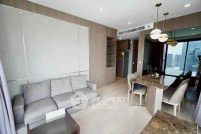 Modern living room with dining area and city view, featuring stylish furniture and lighting.