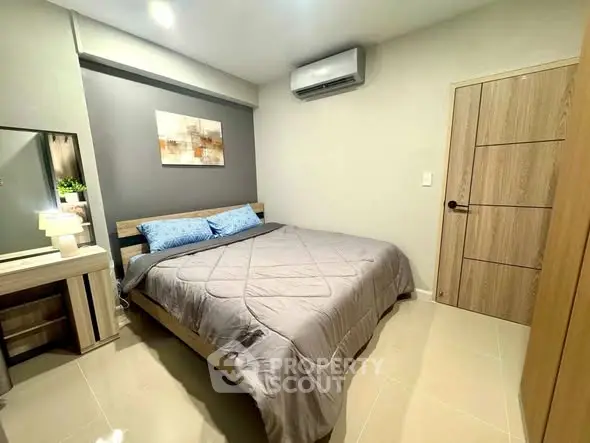 Modern bedroom with stylish decor and air conditioning in a cozy apartment.