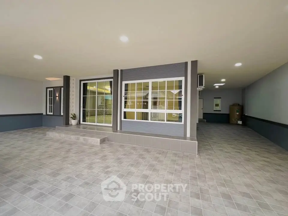 Spacious modern entrance with tiled flooring and large windows, perfect for welcoming guests.