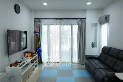 Spacious living room with modern decor and large window for natural light.