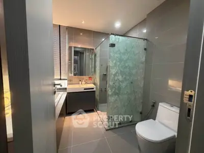 Modern bathroom with glass shower and sleek fixtures in a contemporary apartment.