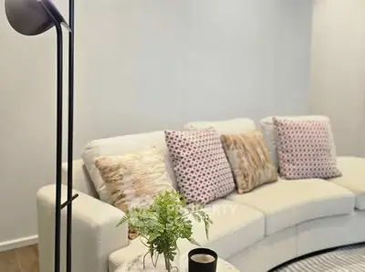 Stylish living room with cozy sofa and decorative pillows, perfect for relaxation.