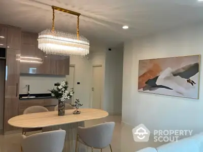 Elegant dining area with modern chandelier and stylish decor in open-plan apartment