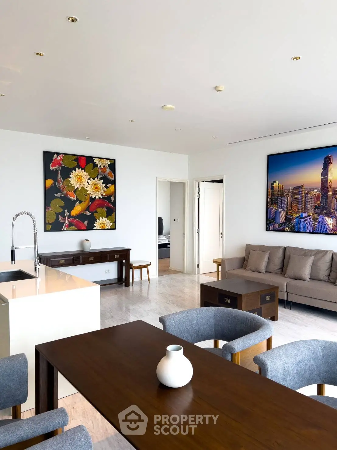 Spacious modern living room with elegant decor and cityscape artwork, featuring a cozy seating area and dining table.