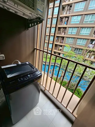 Modern apartment balcony with washing machine and pool view, perfect for urban living.