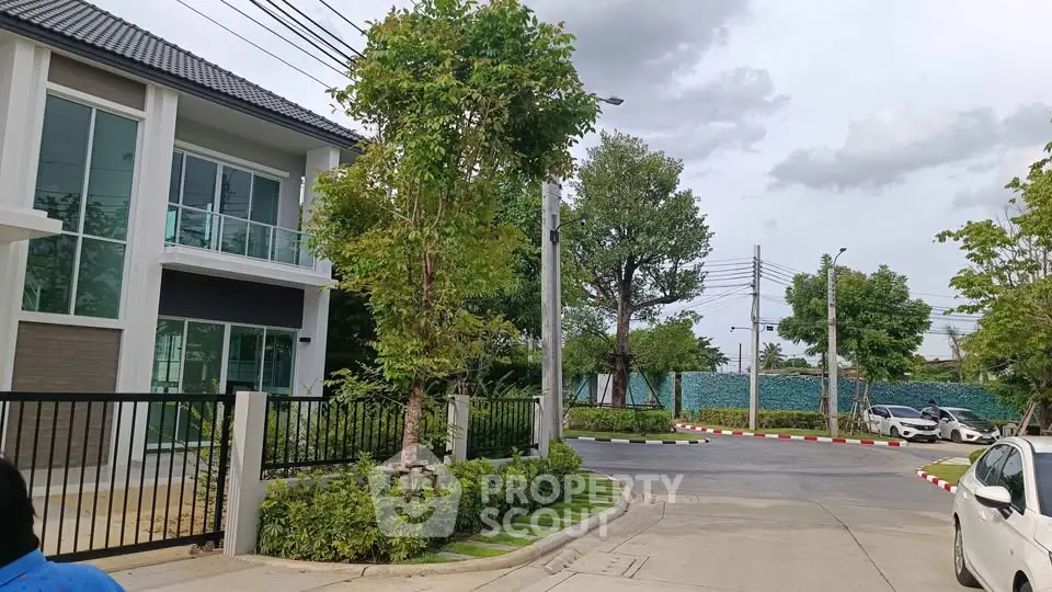 Modern residential building with lush greenery and spacious driveway in a serene neighborhood.