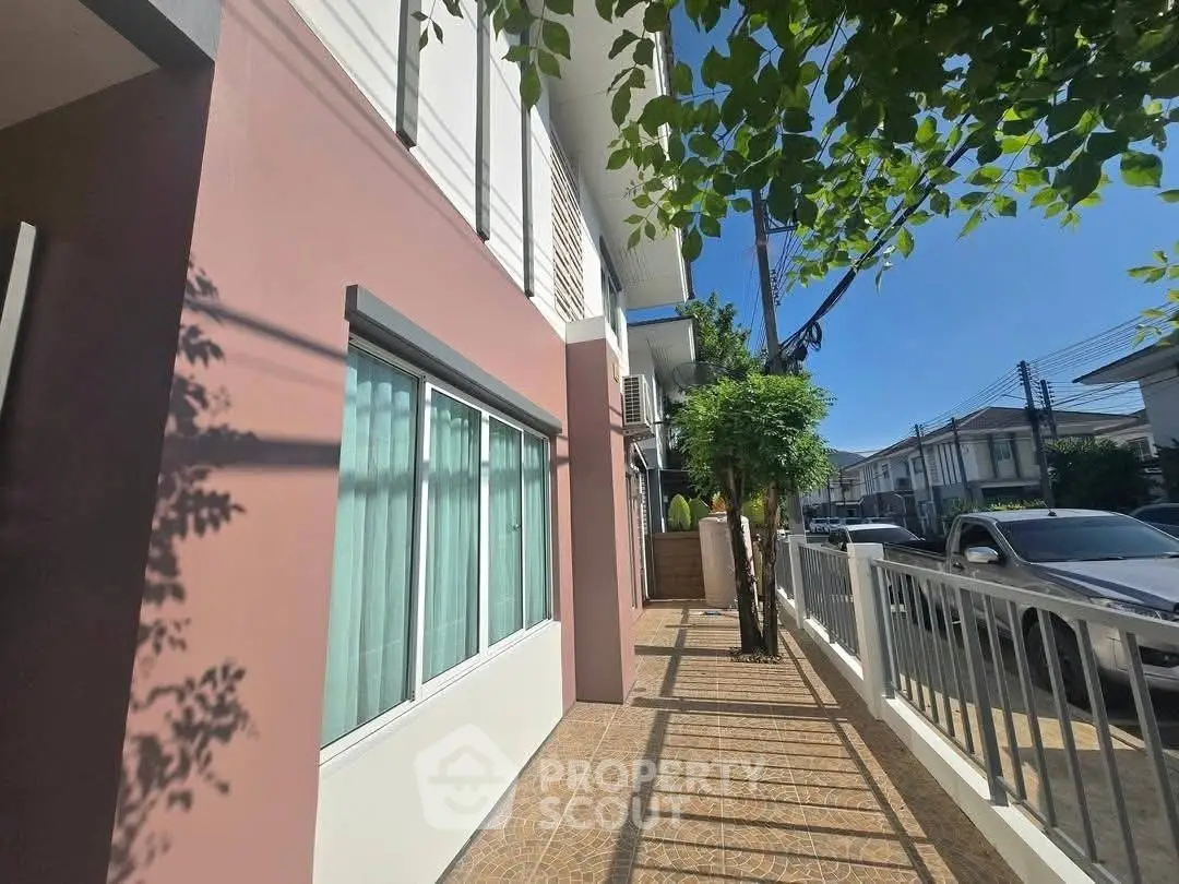 Charming residential exterior with modern facade and sunny sidewalk view.