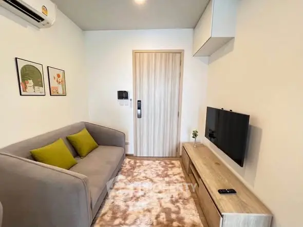 Cozy living room with modern decor, featuring a plush sofa, wall-mounted TV, and stylish wooden accents.