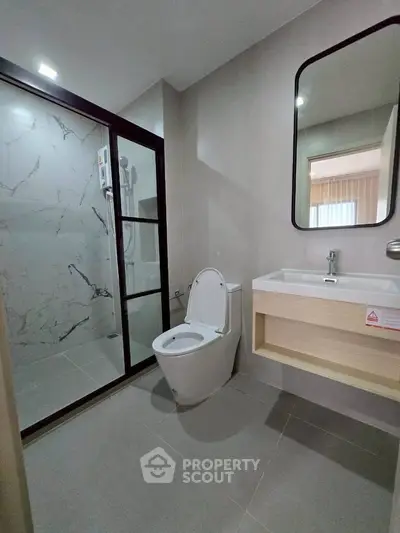 Modern bathroom with sleek design, featuring a glass-enclosed shower and stylish vanity.
