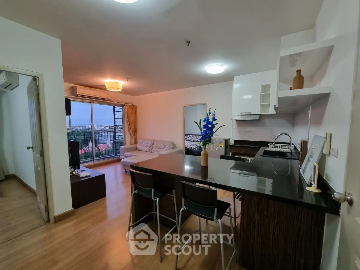 Modern open-layout kitchen and living room with city view, ideal for urban living.
