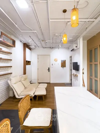 Modern living room with stylish furniture and open layout, featuring cozy seating and elegant lighting.