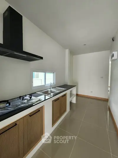 Modern kitchen with sleek countertops and gas stove in a minimalist design.