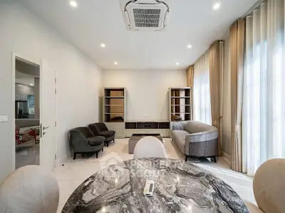 Elegant living room with modern furniture and marble table, featuring ample natural light and stylish decor.