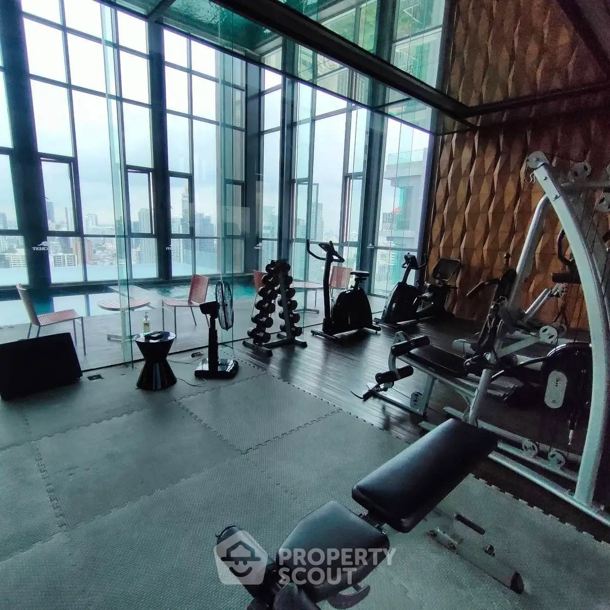 Luxurious high-rise gym with panoramic city views and modern fitness equipment.