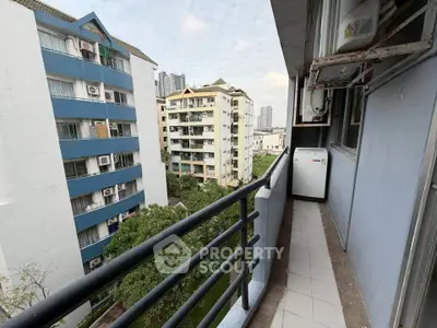 Charming balcony view overlooking urban residential buildings and lush greenery.