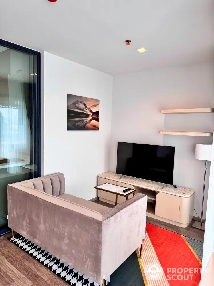 Modern living room with stylish sofa, TV, and decorative shelves in a cozy apartment.