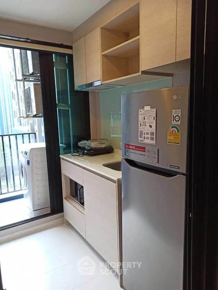 Modern kitchen with sleek cabinetry and stainless steel fridge, offering a compact yet efficient cooking space.