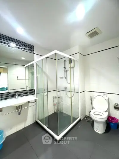 Spacious modern bathroom with glass shower enclosure and sleek fixtures