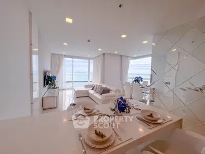Luxurious open-plan living room with stunning ocean view and elegant dining area.
