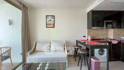 Modern living room with kitchenette and washing machine, featuring stylish decor and natural light.
