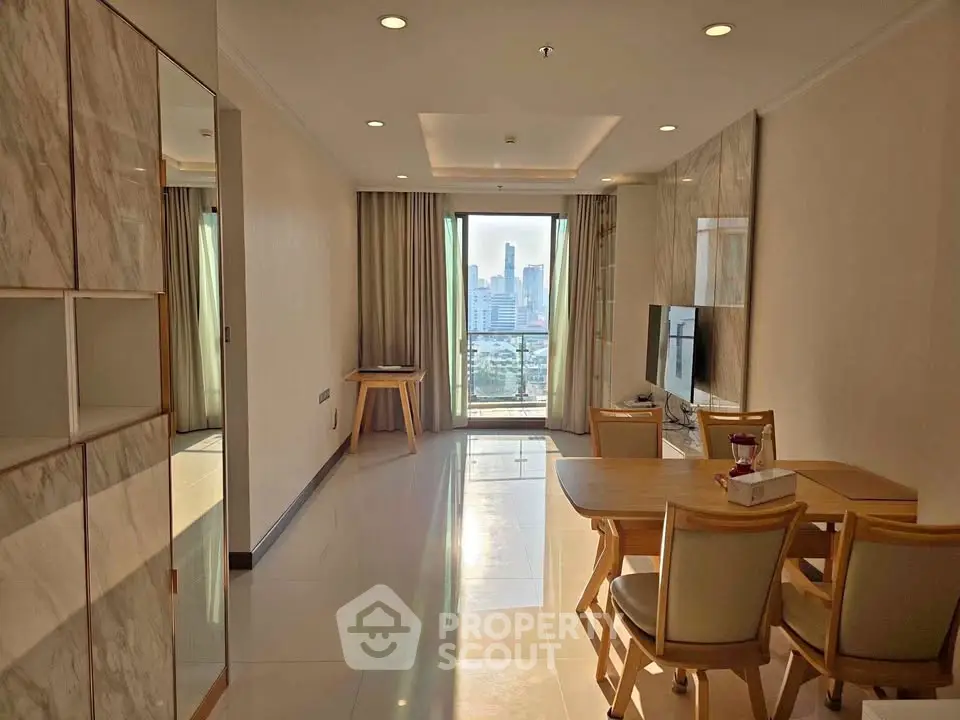Modern living room with city view, elegant furniture, and natural light in a high-rise apartment.
