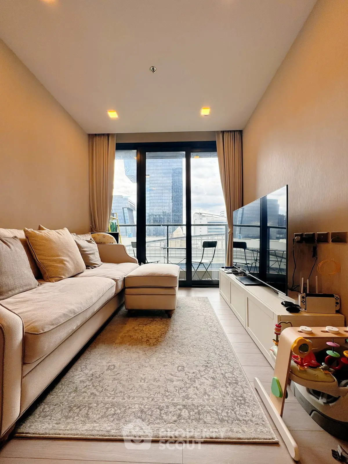 Modern living room with city view, cozy sofa, and large TV, perfect for urban living.