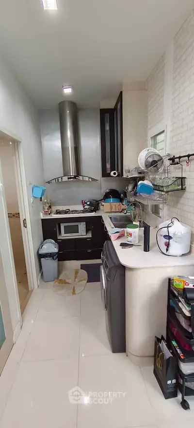 Modern kitchen with sleek appliances and open layout, featuring a gas stove and ample storage space.