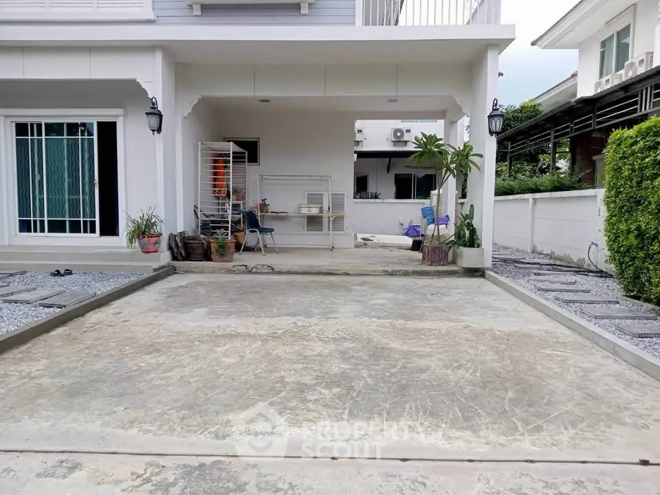 Spacious residential driveway with modern exterior and garden accents