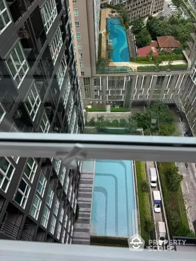 Stunning aerial view of modern apartment complex with luxurious swimming pools and lush greenery.